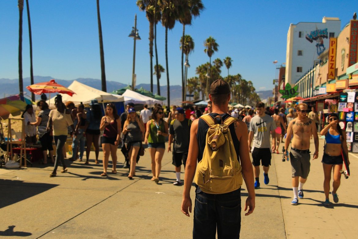 Man with backpack walking in crowd of people